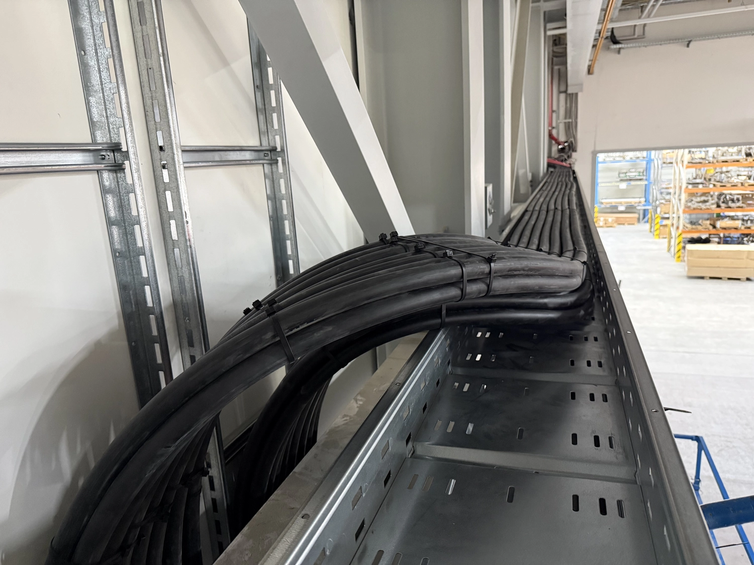 M&S Kabelverlegung GmbH - Dicke schwarze Industriekabel, die mit Kabelbindern gebündelt über eine metallische Kabelrinne geführt werden.Professionelle Kabelverlegung Straubenhardt - 